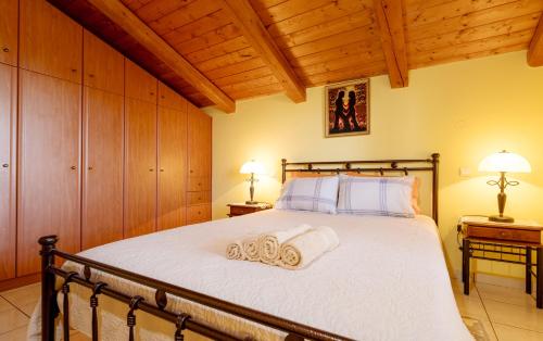 a bedroom with a bed with two towels on it at Arazzo Apartments in Vasilikos