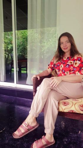 a pregnant woman sitting on a bench in a room at Happy Three Holiday Homes in Hikkaduwa