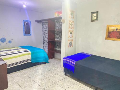 a bedroom with two beds and a shelf at Lirio green hostal in Managua
