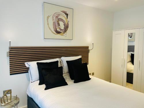 a bedroom with a bed with black and white pillows at Extra large spacious 1 Bedroom private apartment, Nr St Albans City Station, Business, contractor, Parking, WiFi in Saint Albans