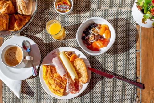 a table with a plate of breakfast foods and a cup of coffee at Le Petit Prince in Sainte-Maxime