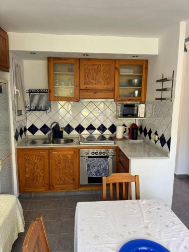 a kitchen with wooden cabinets and a stove top oven at Edificio Es Pujols 10 ALTA TURISTICA in Es Pujols
