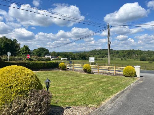 a grassy yard with bushes and a street sign at Killaneen in Ballinamore