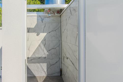 a bathroom with a shower with marble walls at Apartmani Sanja in Vir