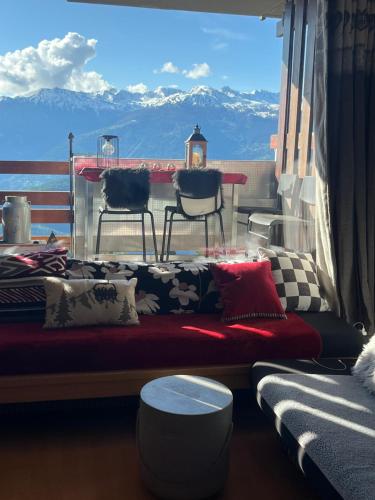 a couch on a balcony with a table and chairs at Studio chaleureux, confortable, avec vue sur les Alpes 2- 3 pers in Anzère