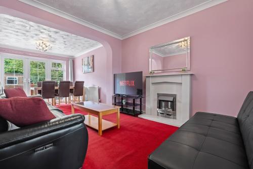 a living room with a couch and a table at Modern 4-Bed Serviced Apartment- Free Parking Wi-Fi - Near CBS Arena -M6 -UHCW in Exhall
