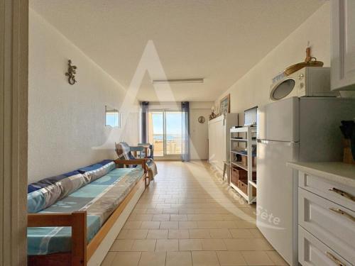 une cuisine avec deux lits dans une chambre avec un réfrigérateur dans l'établissement Studio cabine avec vue mer et parking, à Sète