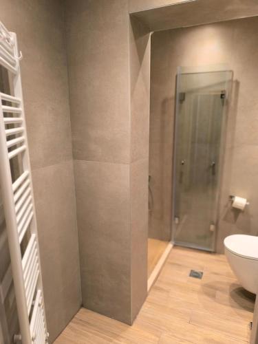 a bathroom with a toilet and a glass shower at Casa Calda in Sirako
