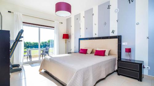una camera da letto con un grande letto con cuscini rosa di Villa Cabanita a Loulé