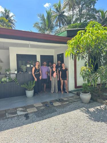 a group of people standing outside of a house at Hello Aliya Hostel in Sigiriya