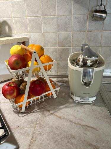 a basket of fruit on a counter next to a juicer at B&b Ponte Pietra in Massazza