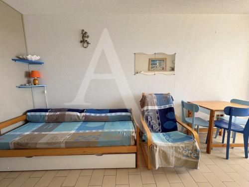 une chambre avec un lit, une table et une chaise dans l'établissement Studio cabine avec vue mer et parking, à Sète