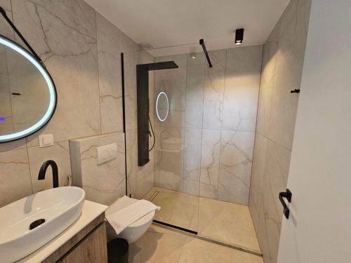 a bathroom with a shower and a toilet and a sink at Bellerive Villas in Kriopigi