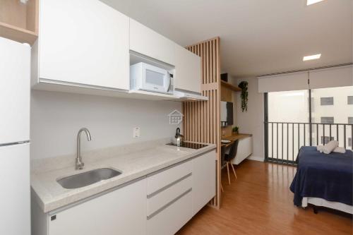 eine Küche mit Spüle und Mikrowelle in der Unterkunft Moradia linda e moderna em um dos melhores bairros de Porto Alegre! in Auxiliadora