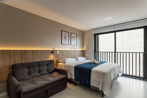 ein Schlafzimmer mit einem Bett und einer Couch in der Unterkunft Moradia linda e moderna em um dos melhores bairros de Porto Alegre! in Auxiliadora