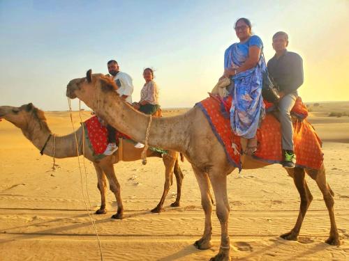 Un groupe de personnes à dos de chameau dans le désert dans l'établissement Style Desert Camp, à Jaisalmer