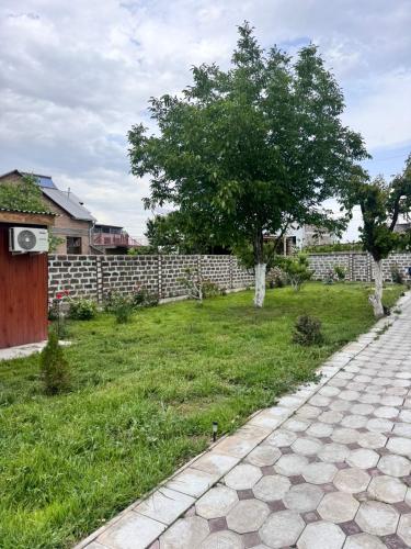 a yard with a brick fence and a tree at Hovakimyans Hotel And Pool N1 in Yerevan Parakar