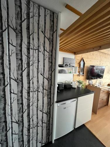 安塞热Studio chaleureux, confortable, avec vue sur les Alpes 2- 3 pers的厨房的墙上画着树