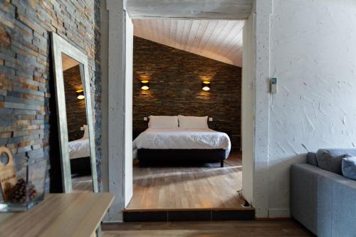 a bedroom with a bed and a brick wall at Auberge Val Moureze Hôtel & Spa in Mourèze