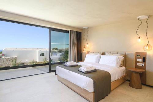 a bedroom with a large bed and a large window at Villa Pefkos Sunset by Villa Plus in Pefki Rhodes