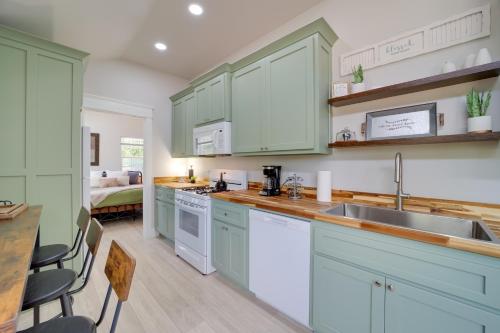 a kitchen with green cabinets and a sink at Cabin in Petrified Forest Near Eufala Lake! in Crowder