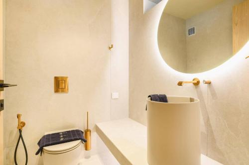 a bathroom with a sink and a toilet and a mirror at Villa Pefkos Cove by Villa Plus in Pefki Rhodes