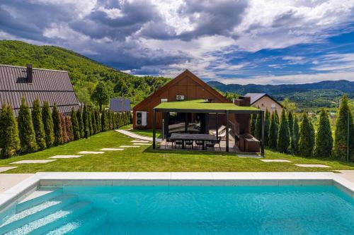 a villa with a swimming pool and a house at Zerm Holiday House with pool, jacuzzi & sauna - Gorski kotar in Mrkopalj