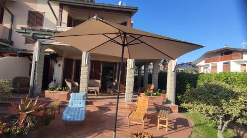 a patio with chairs and an umbrella in front of a house at Il Giardino Sul Mare in Follonica