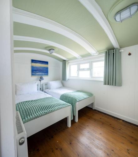 a bedroom with two beds and a window at Windy Ridge in Pagham