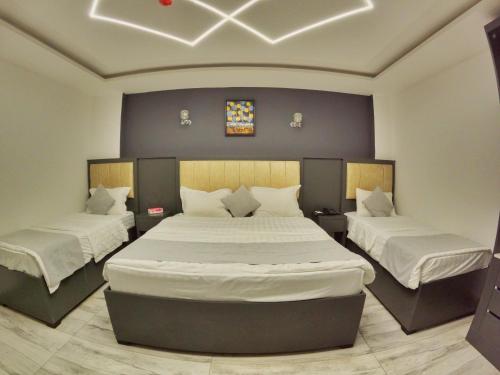 una camera da letto con due letti con lenzuola bianche di Holiday Season Hotel ad Aqaba