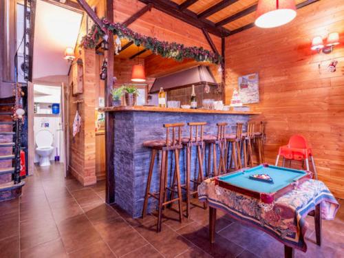 - une cuisine avec un bar avec des tabourets et une table dans l'établissement Villa Jumelia, à Le Mont-Dore