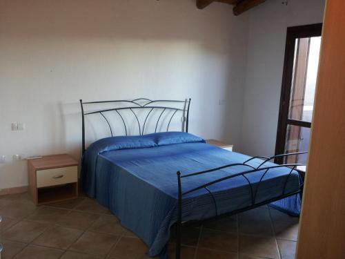 a bedroom with a bed with a blue comforter at Residence Orizzonti 34 in Golfo Aranci