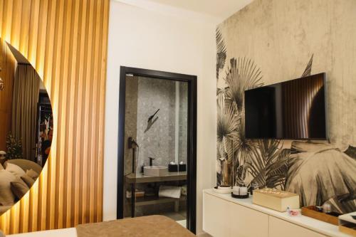 a bedroom with a bed and a tv on a wall at Barneys B&b in Cercola