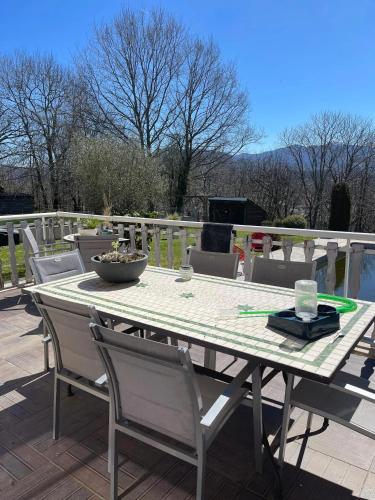 - une table avec des chaises et un bol sur la terrasse dans l'établissement Villa spacieuse avec piscine privée à Saint-Laurent-de-Neste, à Saint-Laurent-de-Neste