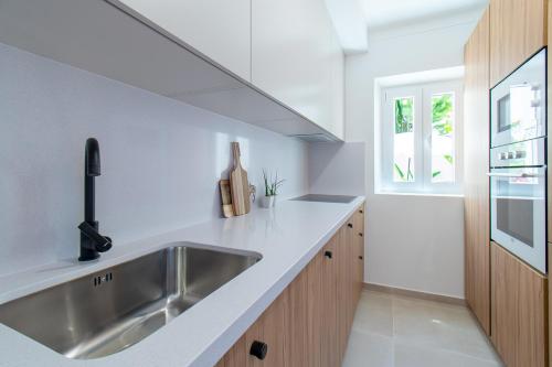 een keuken met een roestvrijstalen wastafel en een raam bij Guadiana River Apartment in Vila Real de Santo António