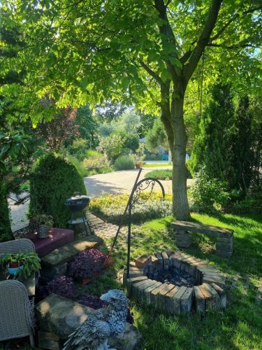 a garden with a fire pit under a tree at Bámbi Apartman in Harsány