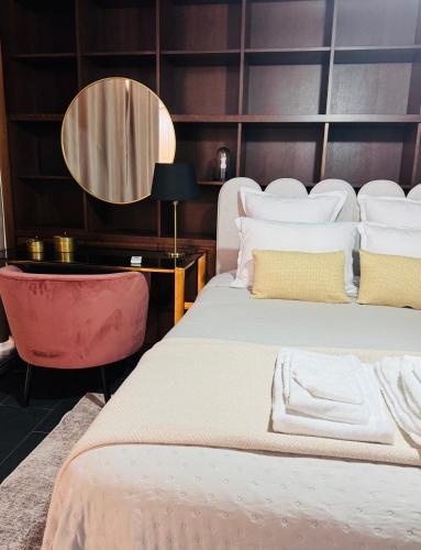 a bedroom with two beds and a table and a mirror at Casa Maramar in Angra do Heroísmo