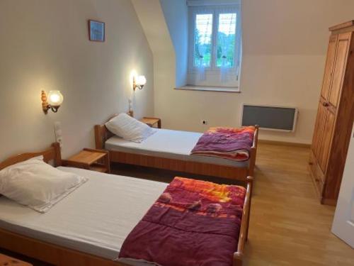 une chambre d'hôtel avec deux lits et une télévision dans l'établissement gite de saintre, à Juilley