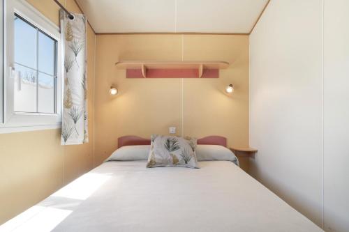 une petite chambre avec un lit et une fenêtre dans l'établissement Alojamiento Rural Coral, à Conil de la Frontera