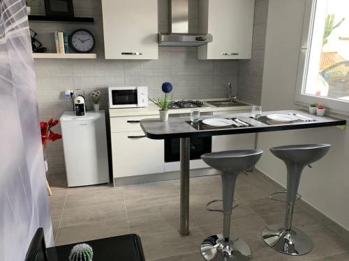 a kitchen with a table and two bar stools at GillyLoft in La Maddalena