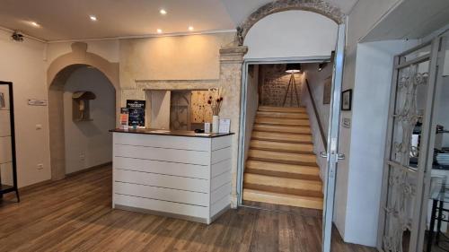 a hallway with an archway and a staircase in a building at Hôtel L'Herbier d'Orange in Orange