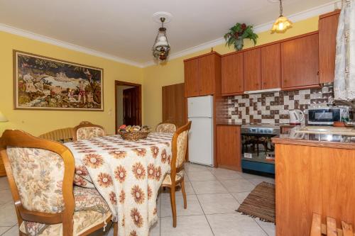 a kitchen with a table and chairs and a kitchen with a counter at Arazzo Apartments in Vasilikos