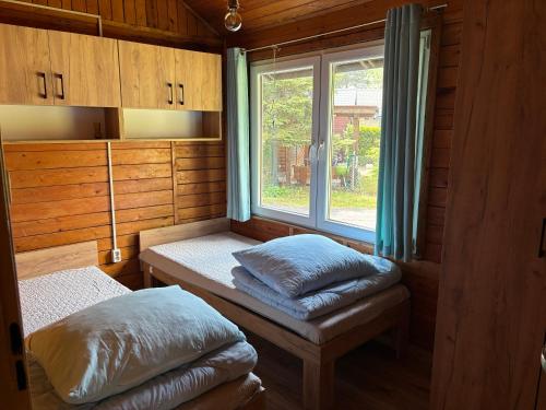 a small room with two pillows and a window at Domek typu Mikołajki na Ośrodku Wędkarsko-Turystycznym Rybaczówka in Turawa