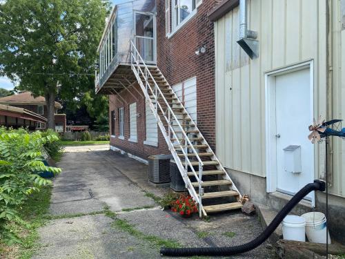 a ladder on the side of a building with a fire hose at Suite A 2 BR w/ Bridge St. view in Elkader