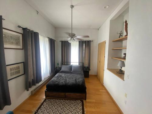 a bedroom with a bed in a room with windows at Suite A 2 BR w/ Bridge St. view in Elkader