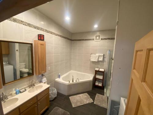 a bathroom with a tub and two sinks and a shower at Suite A 2 BR w/ Bridge St. view in Elkader