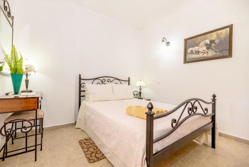 a bedroom with a bed and a nightstand and a table at Arazzo Apartments in Vasilikos