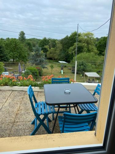d'une table et de chaises avec vue sur le jardin. dans l'établissement Le petit moulin, à Pouzauges