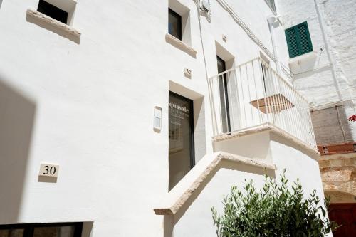 a white building with stairs and a door at Acquasale - Antica Dimora Cialledda in Polignano a Mare