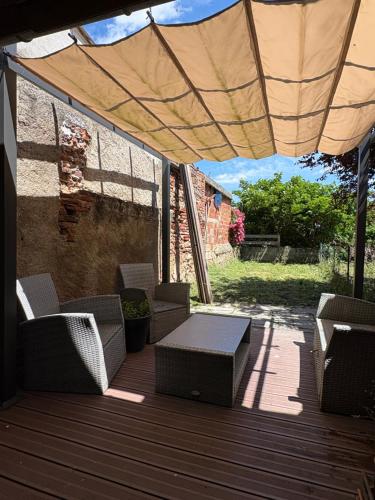 un patio avec des chaises et une table sous un parasol dans l'établissement Maison chaleureuse, à Rabastens
